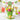 Birthday hat cupcake bouquet with yellow, pink and green buttercream swirls and paper party hats in a lime green pail, styled on a party table with punch and gifts
