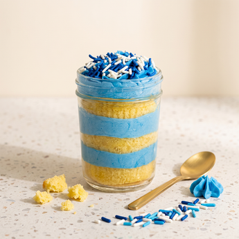 Blue Bliss cupcake jar layered with vanilla cake and blue and white buttercream topped with blue sprinkles