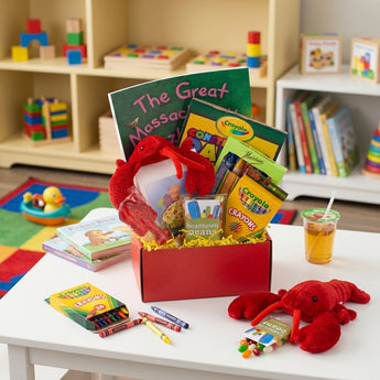 Boston Kidtown Gift Box, a red box with a Massachusetts activity book, Crayola crayons, a lobster plush and Beantown Beans, on a kids play table