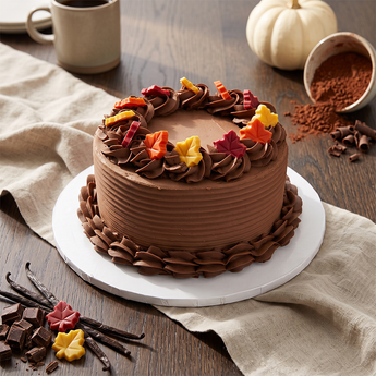 Chocolate Autumn Palette Cake with chocolate buttercream, piped rosettes and autumn leaf accents, on a table with a small pumpkin