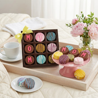 Mother's Day Chocolate Dipped Oreos, nine dipped Oreos spelling MOM in a gift box with a pink cake stand of Oreos, on a breakfast tray with peonies
