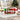 Personalized Christmas candy tackle box with a child's name on the lid and red and green candies on a playroom table by the tree
