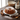 Cinnamon Roll Bundt Cake dusted with sugar beside cinnamon sticks and baking tools