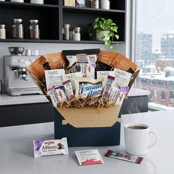 Coffee and tea time snack box with cocoa, tea, cookies and chips on an office kitchenette counter