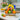Easter Fruit and Treats, a wooden crate of apples, oranges and pears with jam, treats and a yellow bow, on a marble kitchen island