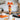 Halloween sweets candy cone layered with candy corn, gummies and jelly beans, tied with an orange bow on a kitchen counter
