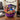 Haunted Sweets Basket, a purple bat print bowl packed with full size snacks and candy bars on a coffee table