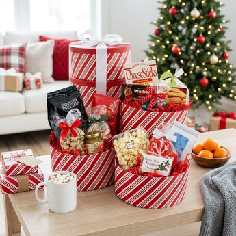 Holiday Bonanza red and white striped Christmas gift box tower with pretzels, shortbread, popcorn and treats on a living room coffee table by the tree