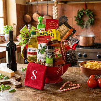 Italian Holiday Feast gift in a red colander with olive oil, sauce, crackers, coffee and a monogrammed towel on a table