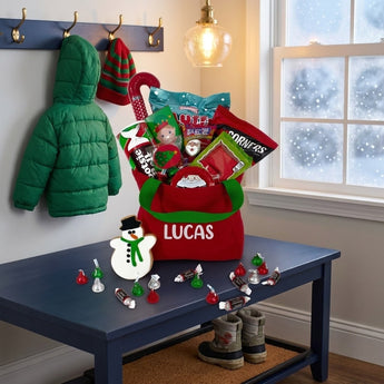 Personalized red holiday gift tote filled with Christmas candy and a snowman cookie on an entryway bench