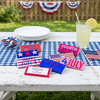 July 4th Hershey's Chocolate Bars, eight Hershey bars in red, white and blue Fourth of July wrappers with a personalized message bar, on a picnic table at a backyard cookout