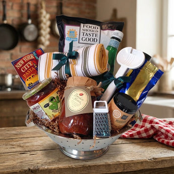 Little Italy New York gift with New York City pasta, salsa, Pomodoro Fresca sauce, coffee, chips and kitchen towel, in a stainless steel colander on a rustic kitchen counter