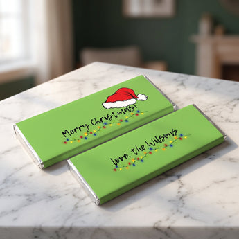 Merry Christmas personalized candy bars in green holiday lights wrappers on a marble counter