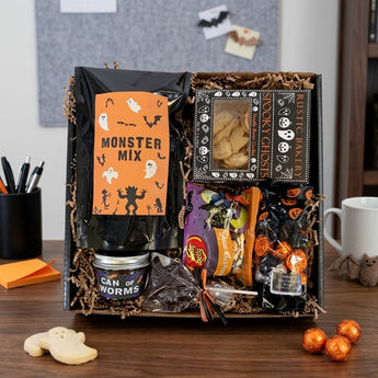 Monster Sweets Halloween snack box with monster mix, ghost shortbread and gummy worms on a home office desk