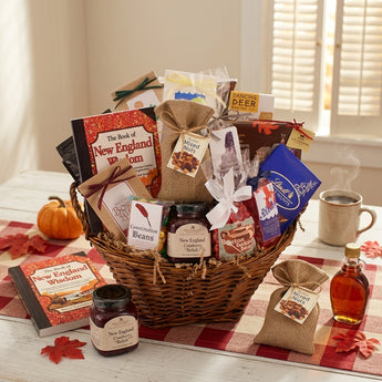 New Englander Gift Basket, a wicker basket of New England snacks, Boston Baked Beans, Constitution Beans, mixed nuts and The Book of New England Wisdom, on a farmhouse table with a buffalo check runner