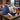New York Knicks Gift, a Knicks cap with a mini basketball, mixed nuts, chocolate bar and treats, on a coffee table in a Brooklyn loft