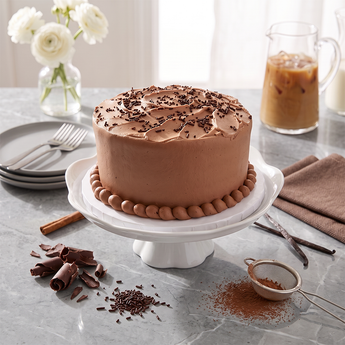 Old Fashioned Chocolate Cake with creamy chocolate frosting and chocolate shavings on a cake stand