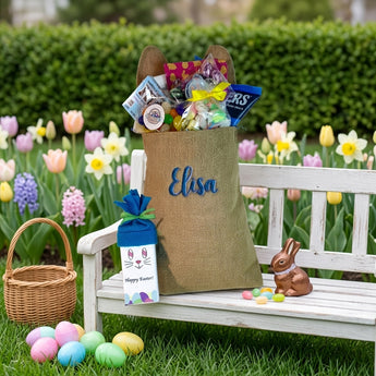 Personalized Bunny Bag, a burlap bunny bag with ears embroidered with a name and filled with Easter candy, on a garden bench before an egg hunt