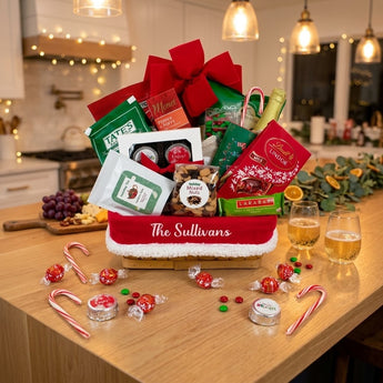 Personalized Christmas gourmet gift basket with a family name liner on a kitchen island set for a holiday open house