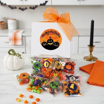 Personalized Halloween candy gift box with a printed Happy Halloween label and nine labelled candy bags on a marble counter