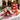 Royal Tower of Treats gift boxes, a red and gold three box tower with two red chevron boxes of popcorn, pretzels and chocolates, styled on a white linen holiday buffet table