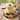 Spring Bird's Nest Cake in white fondant with yellow panels, topped with a chocolate nest of colorful candy eggs
