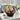 Thinking of You gourmet gift basket with cookies, coffee and snacks on a sunroom table with white hydrangeas
