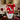 Valentine Pleaser Valentine's Day Gift Basket, a white bucket of Valentine treats with a big red bow, on a dining table set for two