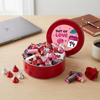Valentine's Day Candy Tin, a red tin of Hershey's chocolates and Valentine candy with a Day of Love lid, on an office desk with a red rose
