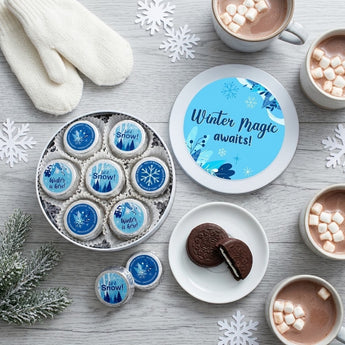 Overhead flat lay of a winter chocolate covered sandwich cookie tin with hot cocoa and mittens