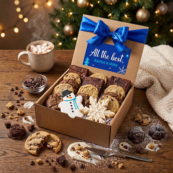 Winter cookies and brownies gift box with snowman and snowflake iced cookies and a blue bow on a rustic table