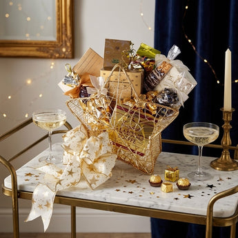 Wish Upon a Star gift basket in a gold wire star basket with gold foil chocolates on a marble and brass bar cart