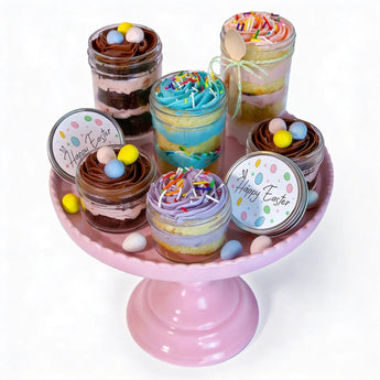 Easter themed colorful layered cupcakes in jars on a pink stand with 'Happy Easter' labels.