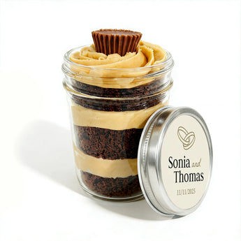 Layered cupcake dessert in a jar with a personalized lid on a white background