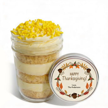 Layered lemon flavored-cupcake dessert in a jar with a customizable 'Happy Thanksgiving!' label on a white background