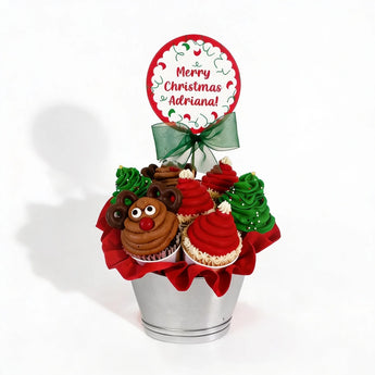 Christmas-themed cupcake bouquet with a personalized topper on a white background
