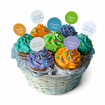 Thank you gratitude basket of colorful cupcakes with decorative toppers on a white background