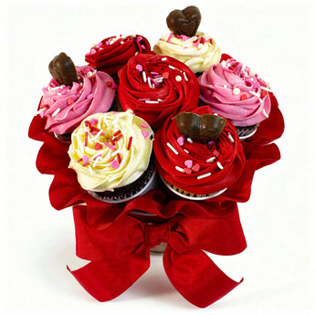 Bouquet of red, pink, and white frosted cupcakes with a red bow on a white background