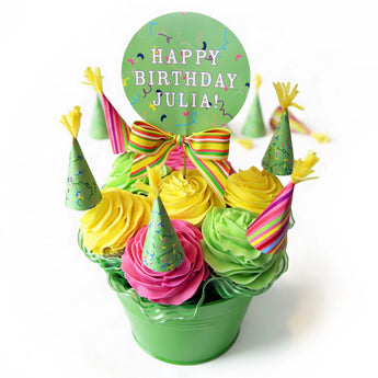 Colorful birthday cupcake bouquet with personalized sign on a white background