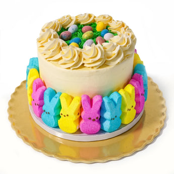 Colorful cake with Peeps around the base on a white background