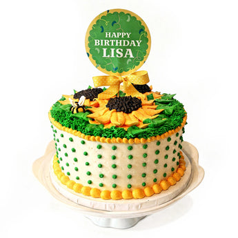 Birthday cake with sunflower design and 'Happy Birthday Lisa' topper on a white background