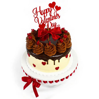 Valentine's Day cake with chocolate frosting, red bow, and 'Happy Valentine's Day' topper on a white background