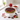 Berry Tart piled with fresh mixed berries on a white cake stand, with strawberries and blueberries on a marble counter