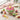 Blooming Flower Cupcake Cake of pull apart cupcakes piped in pink and green buttercream flowers, on a table with cupcakes and plates