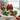 Personalized red Christmas gift box surrounded by holiday snacks and treats on a white kitchen table