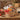 Farm Truckload of Fall Goodies gift with Boston's Best coffee, pumpkin cookie, Ghirardelli chocolate, double dark chocolate bar and chocolate pretzel rods, shown in a plain natural willow basket as the alternate container, on a rustic barn table with apples and corn stalks