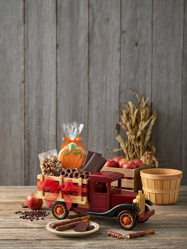 Farm Truckload of Fall Goodies, a red wooden truck filled with fall treats on a rustic barnwood table