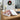 Festive holiday candy assortment with custom logo labels, shown in a plain white gift box and lid as the alternate container, on an office desk with a wreath and white amaryllis