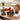 Graduation cookies and brownies with Congrats Grad and 2026 stickers beside a white gift box tied in red ribbon, on a walnut coffee table in a new apartment