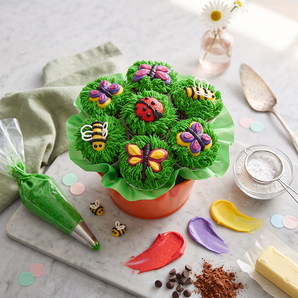 Spring cupcake bouquet with green grass frosting, butterflies, bees and ladybugs in a terracotta pot